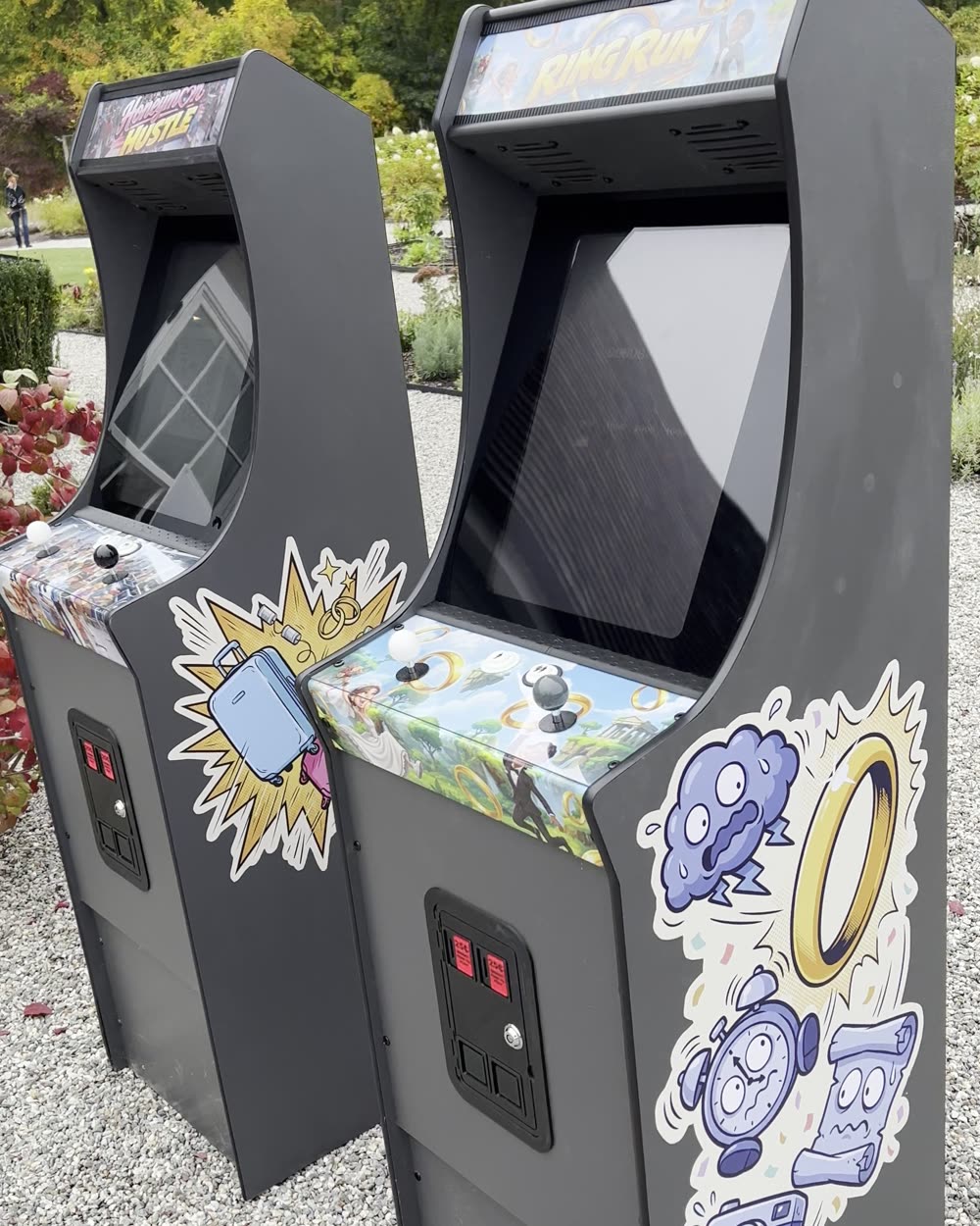 Close angle on both cabinets showing the custom side art and control panels